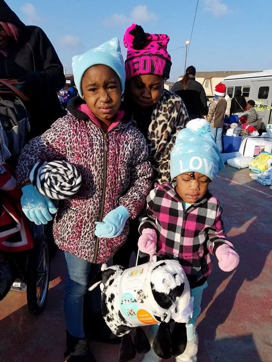 A family of three posing outside in winter clothing